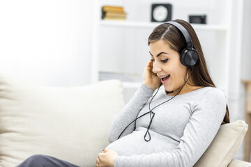 Photo of side view of pregnant woman with headphones.