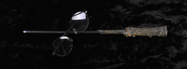 magic wand and glasses on a black background