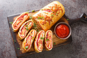 Delicious pizza stromboli roll stuffed with salami sausage and mozzarella cheese close-up on a...