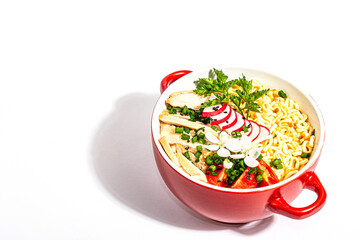 Asian noodles with chicken, vegetables, and herbs are isolated on a white background
