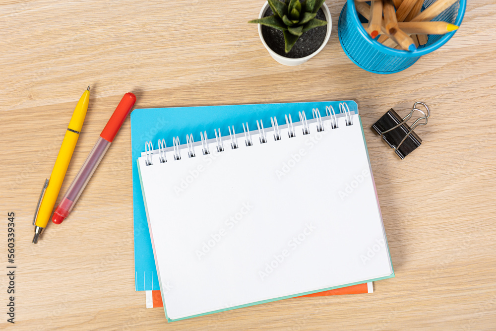 Poster Notebook mockup with school stationery on a wooden table. back to school concept. Blank notepad with copy space. list of goals and plans for new year 2023