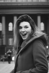 Close up happy emotional woman on street monochrome portrait picture. Closeup side view photography with city building on background. High quality photo for ads, travel blog, magazine, article