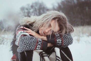 Close up person in traditional clothes sitting outdoors portrait picture. Closeup front view photography with snowy meadow on background. High quality photo for ads, travel blog, magazine, article