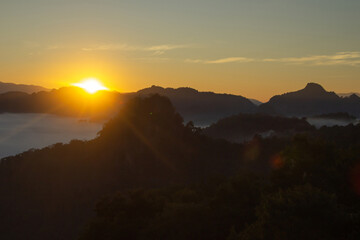 Natural background blurring warm colors and bright sun light. Bokeh or Christmas background Green Energy at sky sunny color orange light patterns plain abstract flare evening clouds blur.
