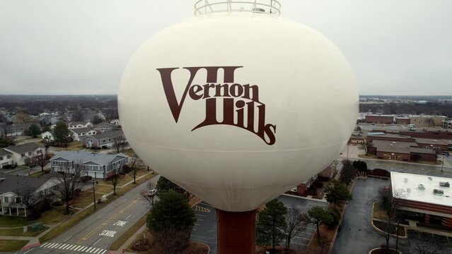 aerial close up of vernon hills, illinois logo on a water tower, flying and revealing the city
