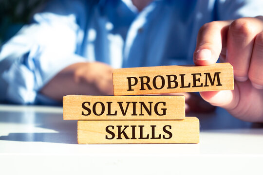 Closeup on businessman holding a wooden block with "Problem Solving Skills" message, Business concept
