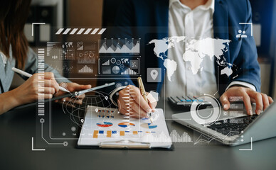 Concept of digital diagram,graph interfaces,virtual icon. Team of business analysts discussing the business strategy in contemporary using on smartphone and tablet with startup project in office...