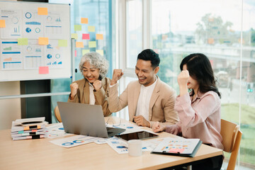 Obraz premium Group of Young Asian business team creative businesspeople coworker, teamwork celebrating achievement and in planning design in creative