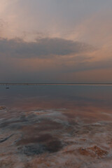 Obraz premium Beautiful view of pink salt lake in Kherson region, Ukraine, Europe. Bright wallpapers. Scenic photography of nature. Amazing seascape. Wooden poles in the water of a pink lake
