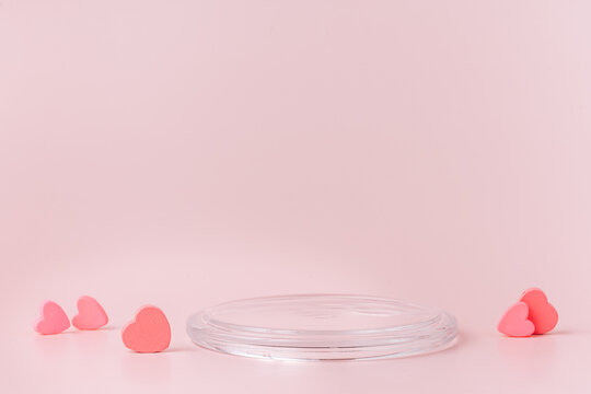 Glass podium with red hearts on a pink background.