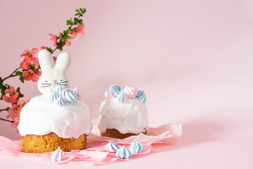 Easter cake and colorful eggs and Easter decorative bunny on a pink background with spring cherry blossoms and copy space. Easter Ukraine orthodox sweet bread.Easter card concept.