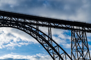 Fototapeta na wymiar “Müngsten Bridge“ is the highest railway bridge in Germany built in 1897. Spanning over river Wupper it connects Solingen with Remscheid. Masterpiece silhouette on a winters day with cloudy blue sky.