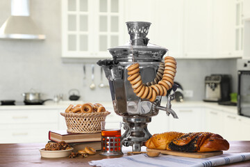 Fototapeta na wymiar Traditional Russian samovar and treats on wooden table in kitchen