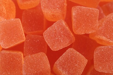 Tasty orange jelly candies as background, closeup