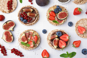 Flat lay composition with tasty crispbreads, mint, sweet berries and figs on light table