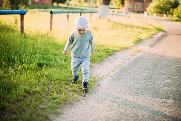 Cute and handsome baby boy 1-2 years old exploring nature in summer, having fun