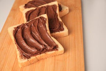 Tasty toasts with chocolate paste on beige background, closeup. Space for text