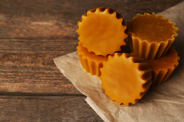 Natural beeswax cake blocks on wooden table, closeup. Space for text