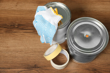 Cans of orange paint and renovation equipment on wooden table, above view. Space for text