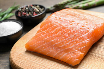 Fresh raw salmon and ingredients for marinade on wooden table, closeup