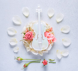 white miniature violin with rose petals, top view
