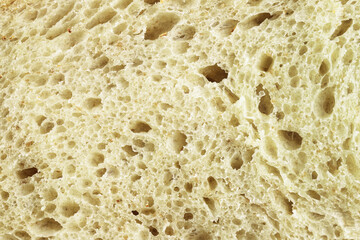 Pattern of pulp of whole grain bread. Texture of wheat bread. Food background. Healthy eating concept. Macro photo.