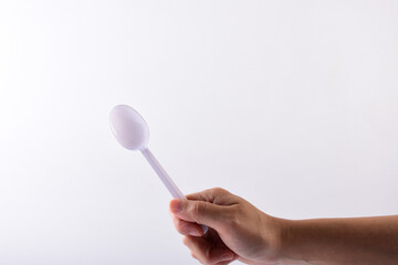 Hand and white spoon plastic isolated on white background.