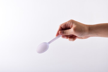 Hand and white spoon plastic isolated on white background.