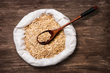 Cucumber seeds in a bag. On a dark wooden background. Seeds in large quantities for sowing and storage in a warehouse. Agriculture.