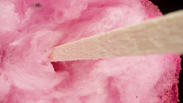 Pink Sweet Cotton Candy on a stick on a Black background. Dolly slider extreme close-up