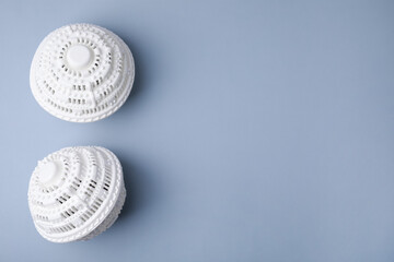 Laundry dryer balls on light grey background, flat lay. Space for text