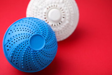 Laundry dryer balls on red background, closeup. Space for text
