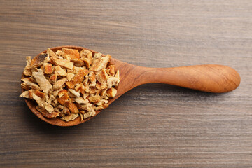 Spoon with dried orange zest seasoning on wooden table, top view