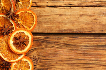 Dry orange slices and anise stars on wooden table, flat lay with space for text