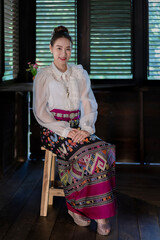 Fototapeta na wymiar Tourist an Asian Thai woman dressed in traditional Thai dress at the old house in Lampang, Thailand. Retro fashion style concept.