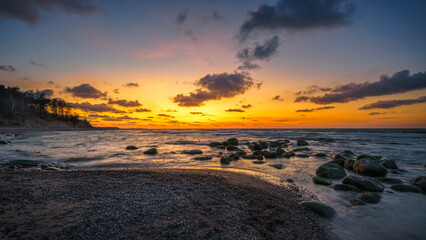 Obraz premium Wonderful orange sunset on the rocky coast of the sea