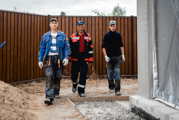 business, building, teamwork and people concept - group of smiling builders outdoors