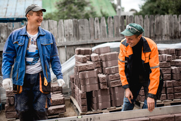 business, building, teamwork and people concept - group of smiling builders outdoors