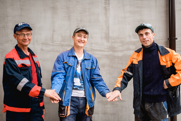 business, building, teamwork and people concept - group of smiling builders outdoors