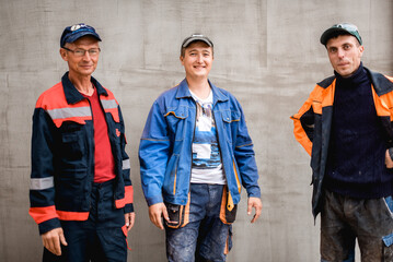 business, building, teamwork and people concept - group of smiling builders outdoors
