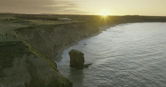 Sunrise at Fortrose cliffs with rock pinnacle on South Island New Zealand, aerial