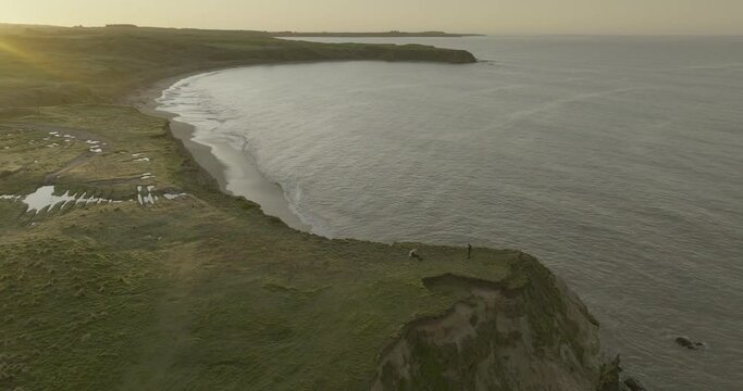 Scenic coastline with Fortrose cliffs tourist destination during sunrise, aerial