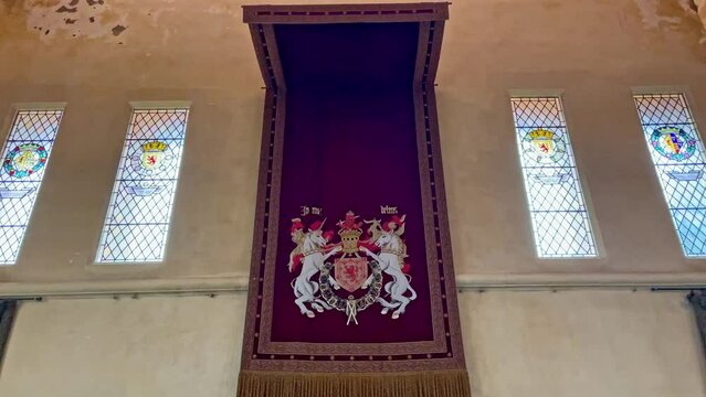 Panning shot of red decorative material with the royalty crest inside Stirling Castle