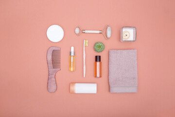 Flat lay of cosmetic products and hygiene items on an orange background. Self care concept. View from above.