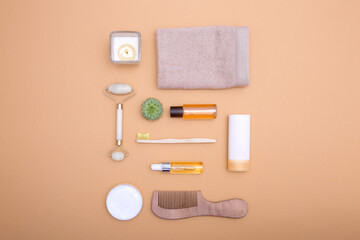 Flat lay of cosmetic products and hygiene items on an orange background. Self care concept. View from above.