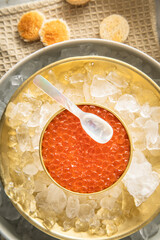 Orange Keta Lachs Kaviar in Dose auf Eis in Glas Schale mit Perlmutt Löffel und Toast Brot auf Serviette hell