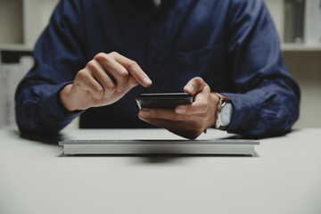 Hand of young business using smart phone at home office, Relax and entertainment concept.