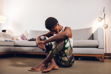 black woman sitting on the living room tired