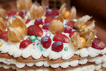 Strawberries and raspberries on a cake with whipped cream close-up
