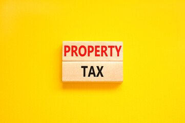 Property tax symbol. Concept words Property tax on wooden blocks. Beautiful yellow table yellow background. Business and property tax concept. Copy space.